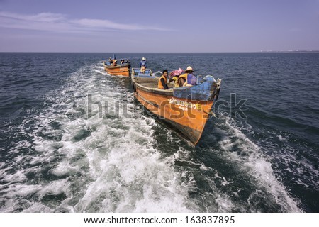 KANNUR, INDIA - DECEMBER 22, 2011: Fishermen set out to sea from Mapilla Bay harbour on a fine sunny morning on December 22, 2011 near Kannur, Kerala, India.