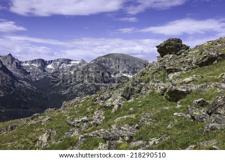Estes Park, Colorado, USA - The Rocky Mountains with snow on the high slopes together with rocks and grasses near Estes Park, Colorado, USA.