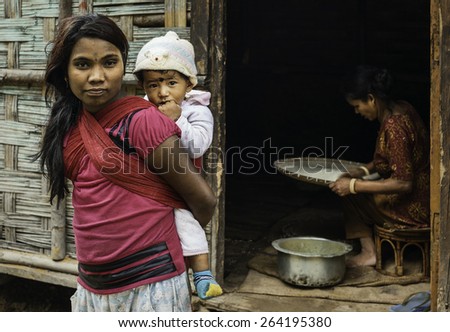 TAWANG, INDIA - SEPTEMBER 19, 2011: Itinerant road workers, grandmother, mother carrying baby, prepare breakfast in a shack by the roadside on September 19, 2011 Tawang, Arunachal Pradesh, India.