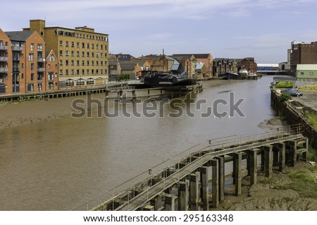 Hull, Humberside, UK. River Hull at low tide with view of Scale Lane swing brige (open), beached obsolete ship, and flanked by buildings near the estuary, Hull, Humberside, UK.