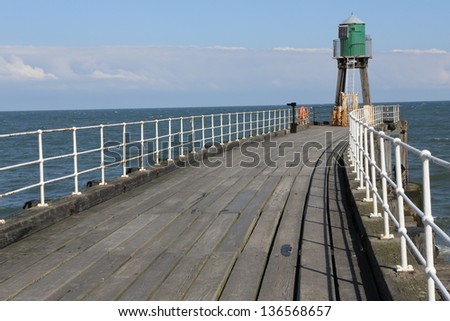 Whitby Pier with old light beacon at the end.