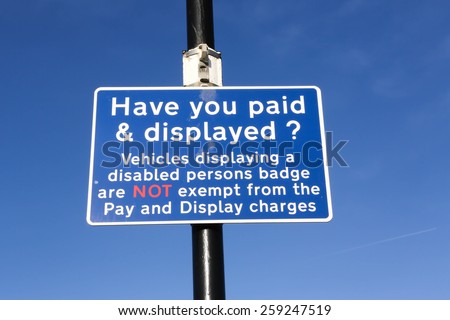 Car park sign. Have you paid & displayed your ticket? Money concept against a clear blue sky background