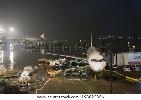 Guangzhou, China - April 29, 2014:  Sichuan Airlines  passenger flight being loaded up with cargo at Guangzhou Baiyun International Airport at night.