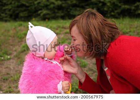 mother with her little daughter sniffing a small flower