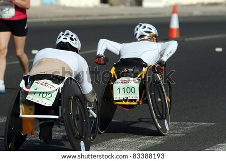 LANZAROTE , SPAIN - NOVEMBER 29: A pair of unidentified disabled athletes compete in a wheelchair event during the 2009 Lanzarote marathon on November 29, 2009 in Lanzarote, Spain.