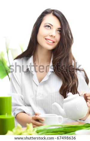 Woman dirinking tea smiling and looking at camera wearing formal clothes