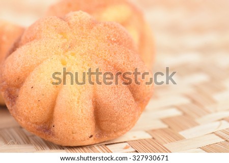 Kuih bahulu, Malay sweet egg sponge muffin cake on bamboo mat. (selected focus)