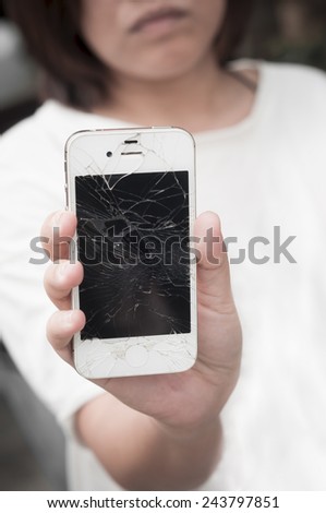 Upset woman holding broken mobile smartphone