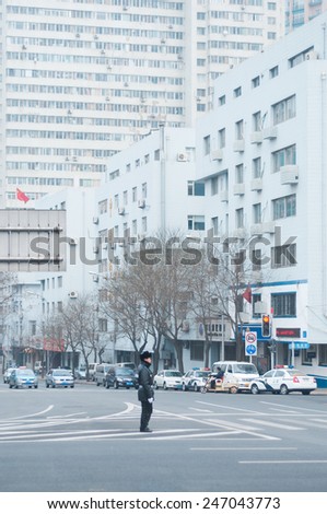Dalian, China January 18, 2015: Traffic policeman directing cars in a crossing road