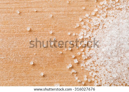 Macro detail of salt crystal grain on wood background.