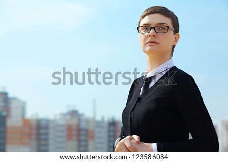 portrait of a young businesswoman in glasses on the background buildings