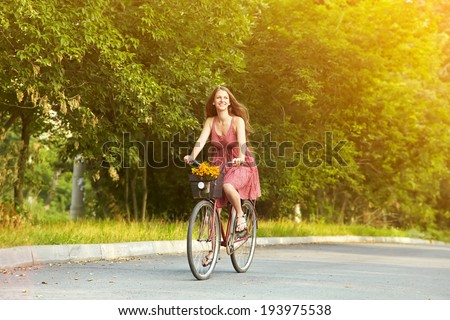 young beautiful woman riding a bicycle in a park. Active people. Outdoors