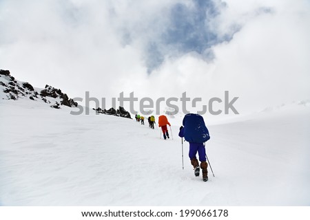 Group of hikers in the mountain. Climb to the top. winter hiking