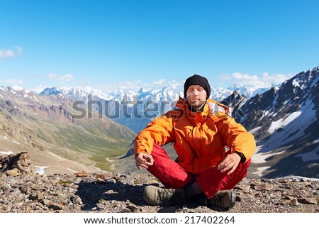 mountaineer meditates on a background of mountains. man outdoors. healthy lifestyle