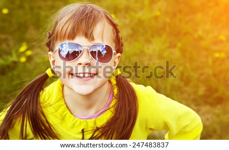 cheerful girl in sunglasses in the park. children outdoors. vacation in the summer park