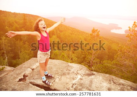 funny little  happy girl on the mountain top. children outdoors. inspiration