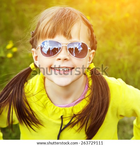 cheerful girl in sunglasses in the park. children outdoors. vacation in the summer park