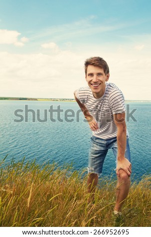 Portrait of a young smiling man on nature background. good looking man summer outdoors