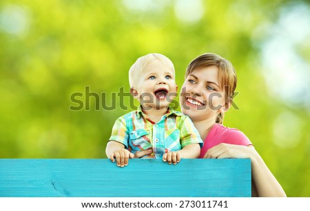 outdoor portrait of mother and son on green background. child and mom walk in the summer park.