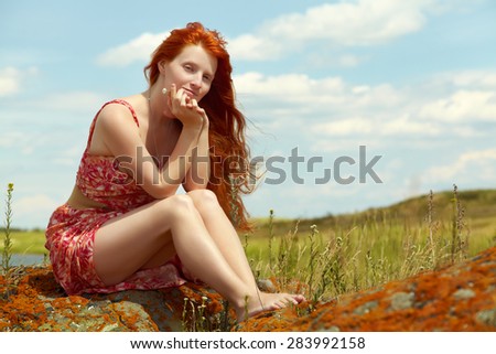 sexy redhead woman in a dress outdoors. Beautiful stylish romantic young girl on nature background