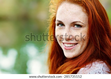portrait af a beautiful redhead woman outdoors. stylish romantic young girl on a walk in the park. red hair and freckles
