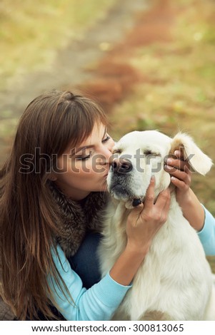 Young golden retriever for a walk with his owner. Dog breed labrador with woman outdoors