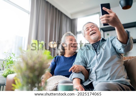 happiness asian old senior retired couple enjoy videocall to family together on sofa in living room at home,asian people use smartphone communication to family home isolation ides concept Сток-фото © 