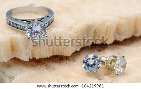 Beautiful diamond engagement ring and diamond stud earrings on coral