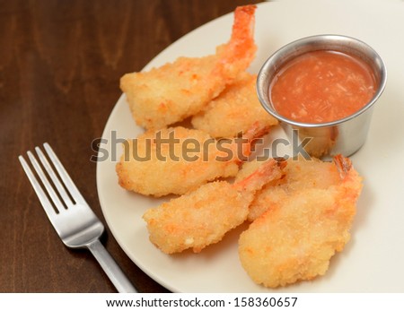 fried shrimp and hot sauce on wood background