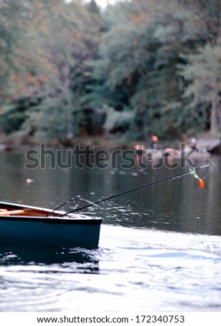fishing in a canoe with a fishing pole in autumn in Maine