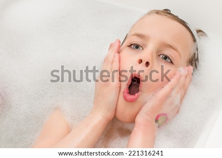 Pretty Little Girl Playing in the Bathtub Making a Goofy Face