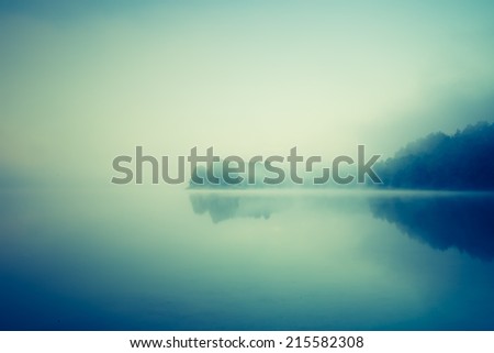 vintage photo of sunrise over foggy lake