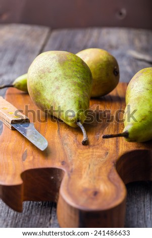 Long pears on wooden cutting board and ancient wooden table