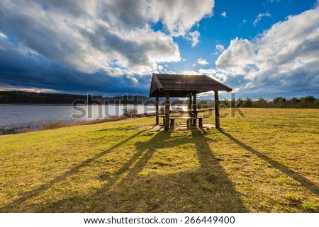 Beautiful landscape of wooden hut under dramatic sky. Landscape with bad weather and vibrant colors.