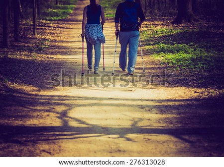People play sport in forest. Nordic walking couple.