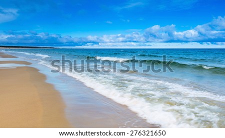 Beautiful beach landscape with cloudy sky and sea with waves. Baltic sea coast near Gdansk in Poland.
