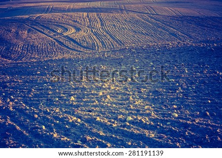 Vintage photo of plowed field in calm countryside. Agricultural landscape with old fashioned colors