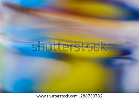 Abstract background of color reflections in thick glass vase. Macro abstract background