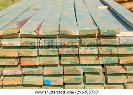 Boards from sawmill for house roof construction. Wooden planks lying in the yard.