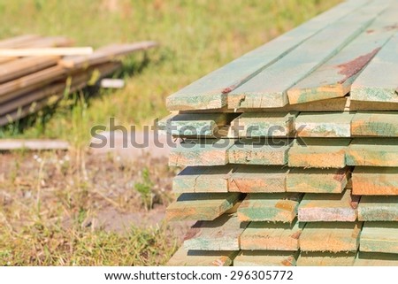 Boards from sawmill for house roof construction. Wooden planks lying in the yard.