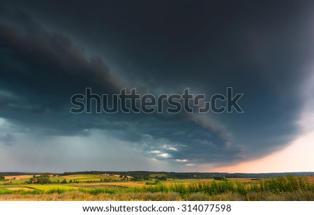 Storm clouds over wheat field. Danger weather with dark sky over fields