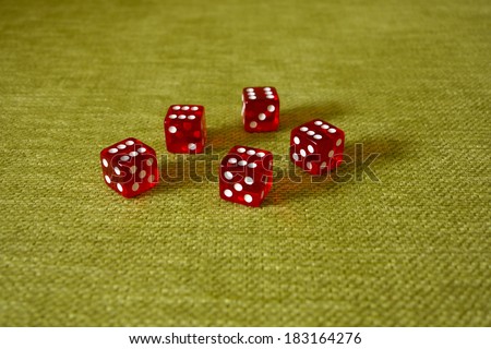 Five dice on a green cloth background with a drop of sixes