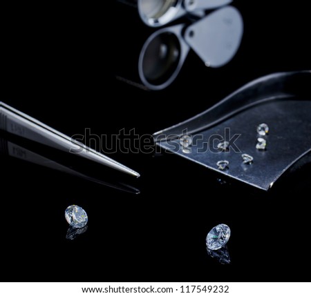 diamond, tweezers on a black background , and  stone shovel with other diamonds, diamond cut loupe