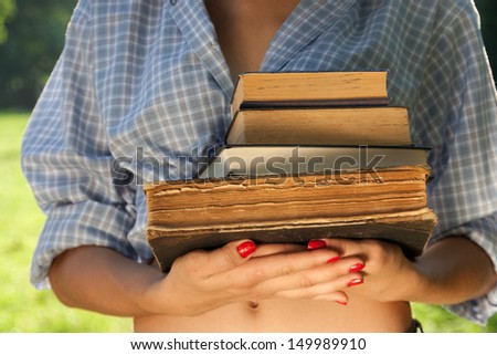 Girl with books in the park. Student.