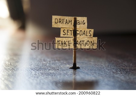 Dream Big, Set Goals, Take Action, concept, tags on the table.