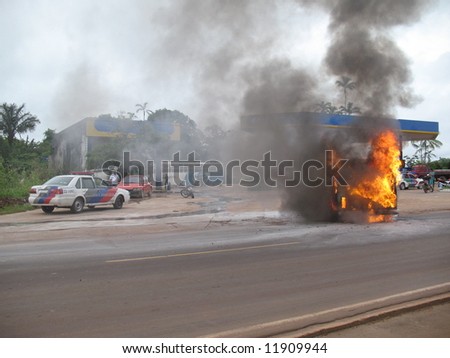 Danger of an explosion, car completely enveloped in flames  near a petrol station