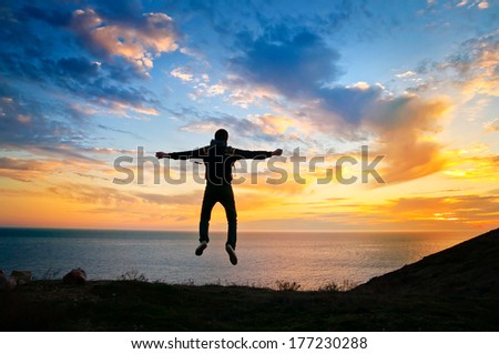 Healthy young man jumping at sunset