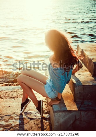 young beautiful  girl on a background of sea and sun