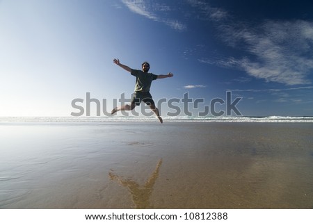 Happy man jumping in a sunny beach