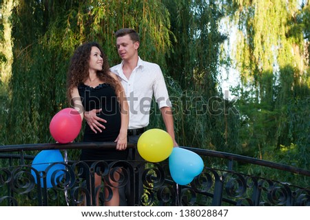 happy young couple in love with a bunch of balloons in the park